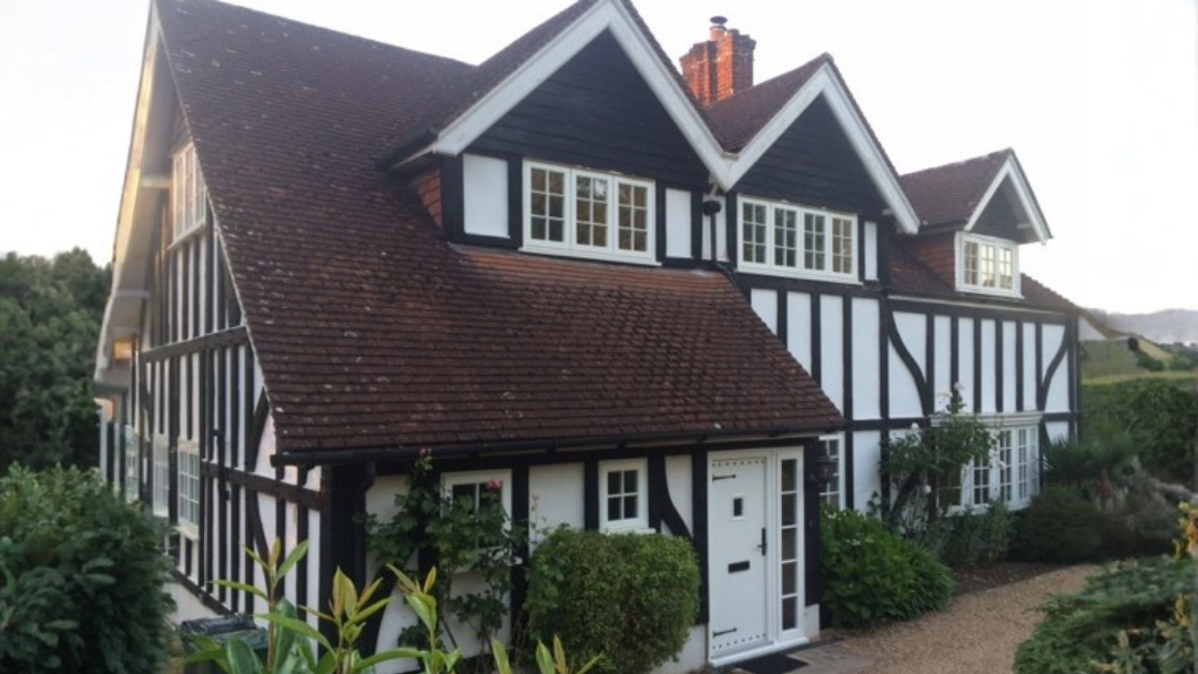 Tudor style house with multiple timber alternative windows in white