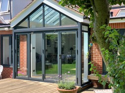 Grey bi-fold doors with pitch roof from a kitchen extension