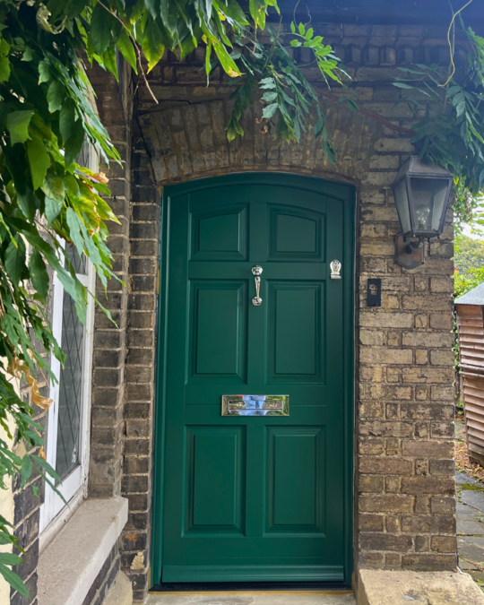 Green timber front door in brick house with chrome furniture (Mustang Green)