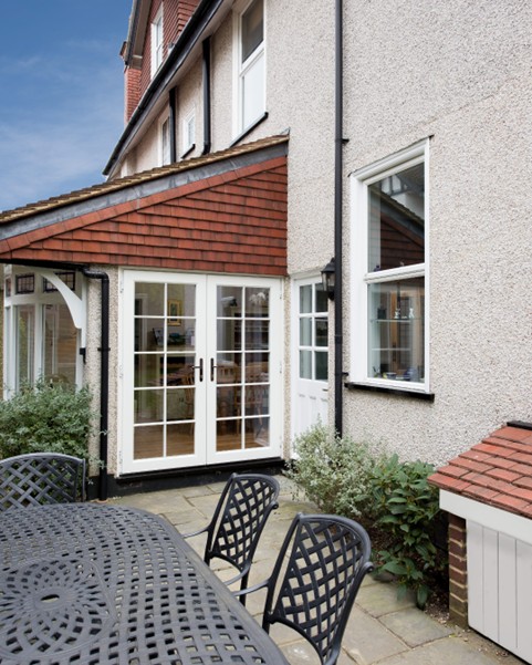 PVC french doors in white with a surround and astragal bars