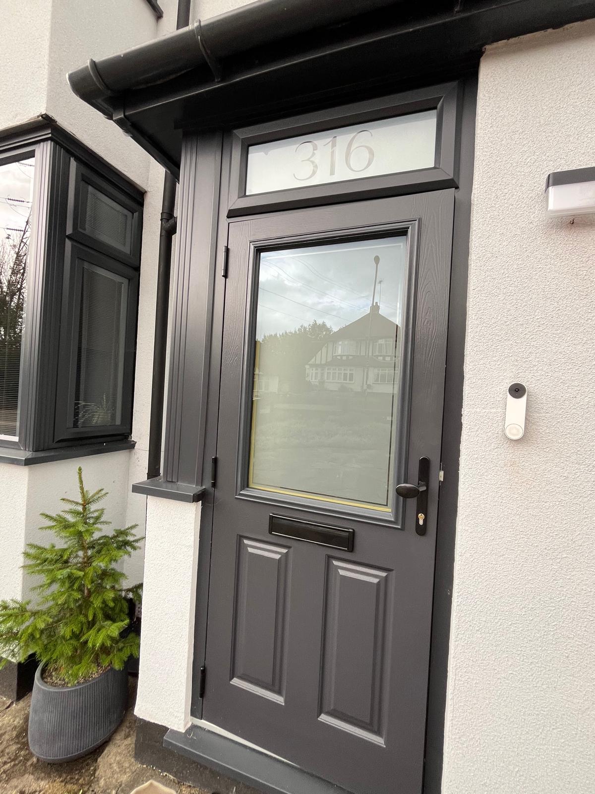 Grey composite front door with black matt furniture and custom frosted glass