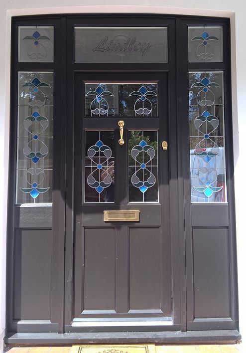 Black English Door Company front door with custom glass and brass furniture