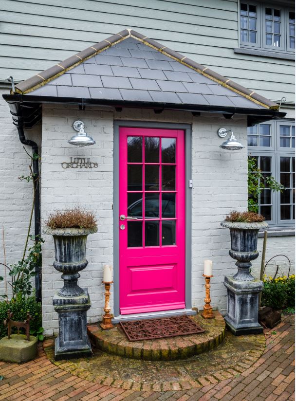 Bright pink timber front door with chrome furniture