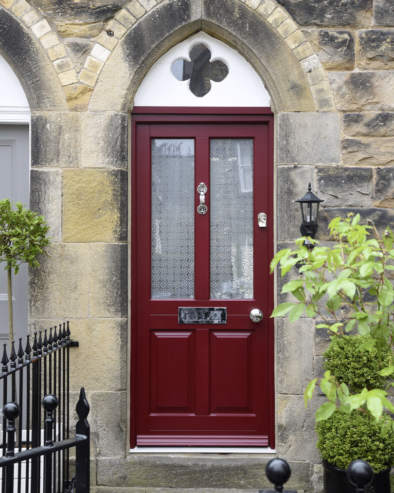 dark red timber front door with cathedral style toplight