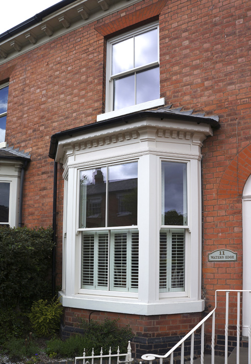 vertical sliding sash white timber window outside with red brick